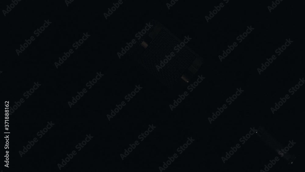 Micrófono profesional de sobre mesa con cable y montado en su base con un fondo negro, e iluminación en movimiento.
