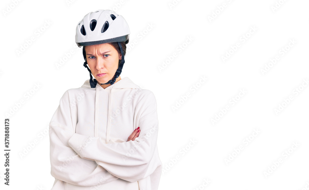 Beautiful brunette young woman wearing bike helmet and sporty clothes skeptic and nervous, disapproving expression on face with crossed arms. negative person. Beautiful brunette young woman wearing bike helmet and sporty clothes skeptic and nervous, disapproving expression on face with crossed arms. negative person.