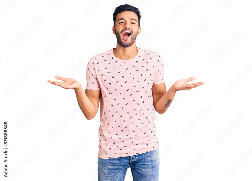 Young handsome hispanic man wearing casual clothes celebrating victory with happy smile and winner expression with raised hands Young handsome hispanic man wearing casual clothes celebrating victory with happy smile and winner expression with raised hands