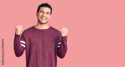 Hispanic handsome young man wearing casual clothes celebrating surprised and amazed for success with arms raised and open eyes. winner concept.