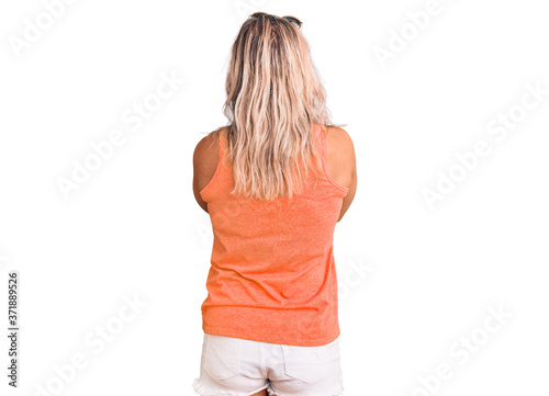 Middle age fit blonde woman wearing casual summer clothes and sunglasses standing backwards looking away with crossed arms
