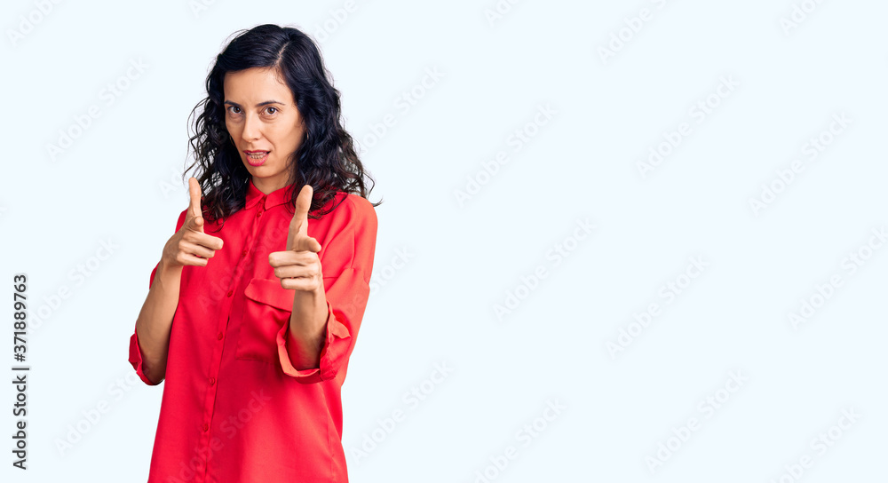 Young beautiful hispanic woman wearing casual clothes pointing fingers to camera with happy and funny face. good energy and vibes. Young beautiful hispanic woman wearing casual clothes pointing fingers to camera with happy and funny face. good energy and vibes.