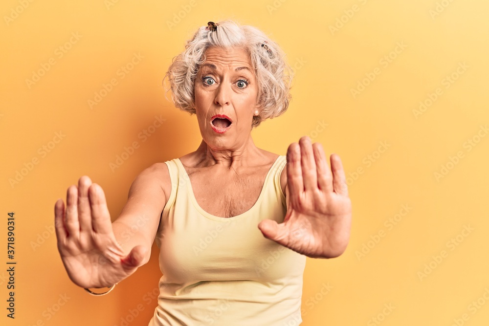 Senior grey-haired woman wearing casual clothes doing stop gesture with hands palms, angry and frustration expression Senior grey-haired woman wearing casual clothes doing stop gesture with hands palms, angry and frustration expression