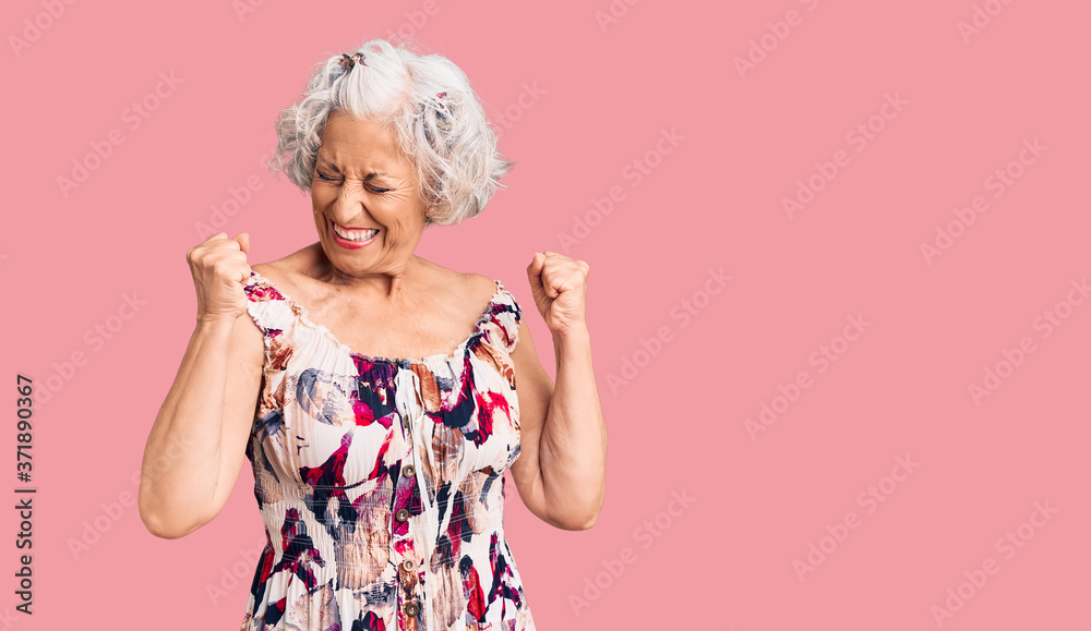 Senior grey-haired woman wearing casual clothes excited for success with arms raised and eyes closed celebrating victory smiling. winner concept.