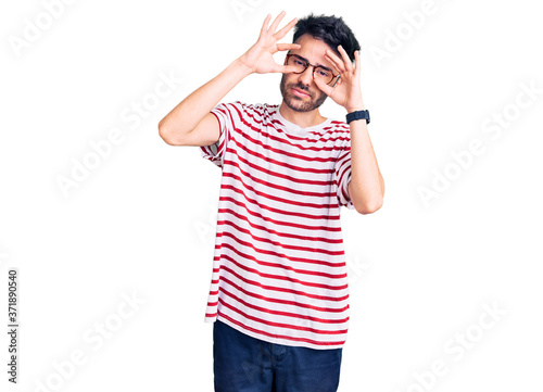 Young hispanic man wearing casual clothes trying to open eyes with fingers, sleepy and tired for morning fatigue