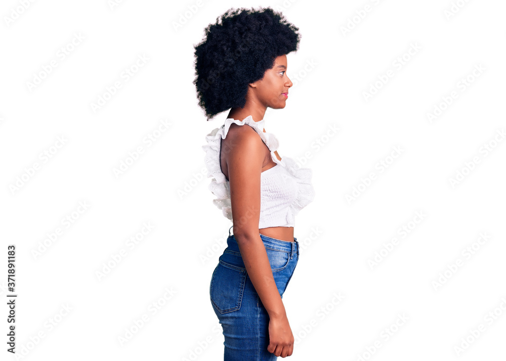 Young african american woman wearing casual clothes looking to side, relax profile pose with natural face with confident smile. Young african american woman wearing casual clothes looking to side, relax profile pose with natural face with confident smile.