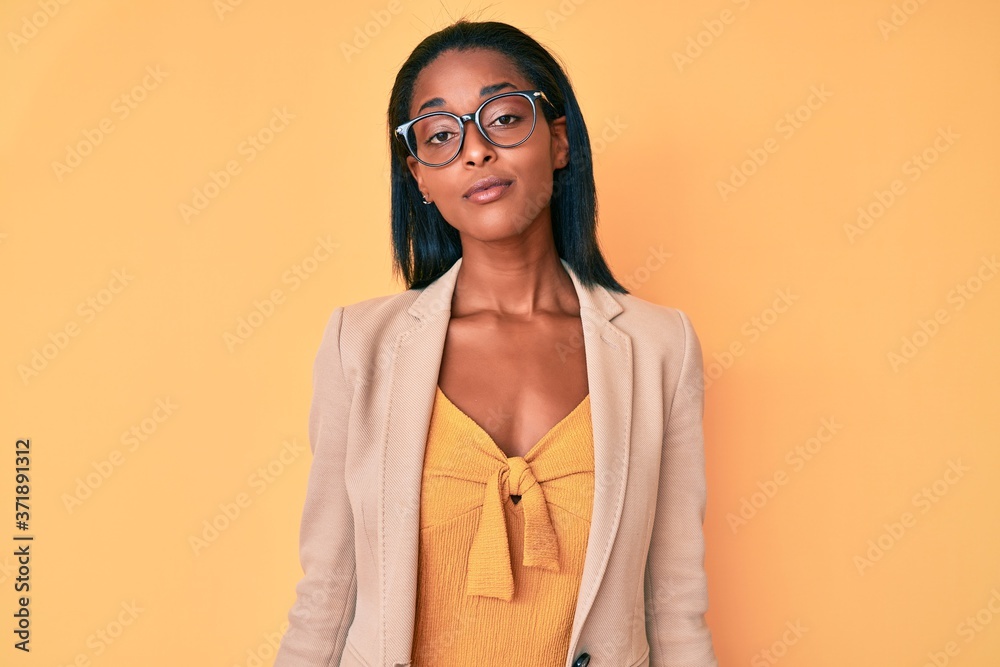 Young african american woman wearing business clothes relaxed with serious expression on face. simple and natural looking at the camera.