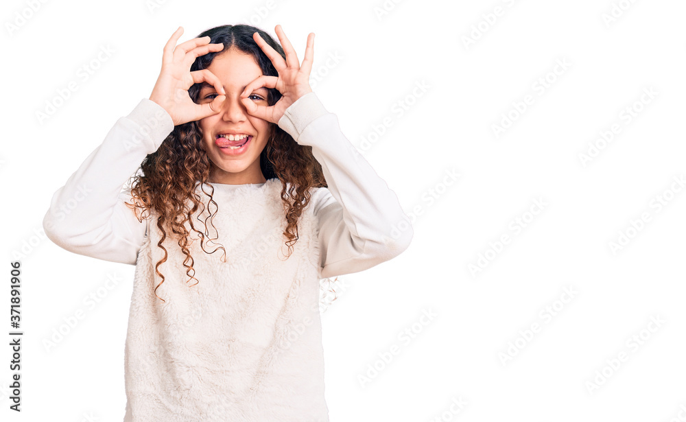 Beautiful kid girl with curly hair wearing casual clothes doing ok gesture like binoculars sticking tongue out, eyes looking through fingers. crazy expression. Beautiful kid girl with curly hair wearing casual clothes doing ok gesture like binoculars sticking tongue out, eyes looking through fingers. crazy expression.
