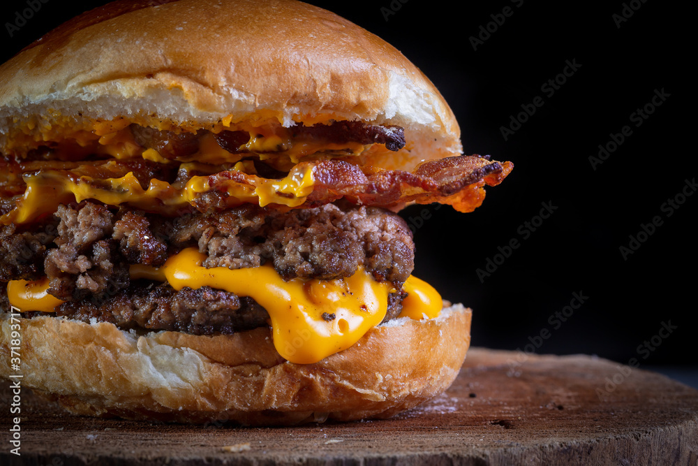 Two smash burgers with cheddar cheese, bacon and garlic sauce. Rustic craft burger. - obrazy, fototapety, plakaty 