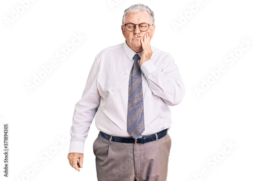 Senior grey-haired man wearing business clothes touching mouth with hand with painful expression because of toothache or dental illness on teeth. dentist