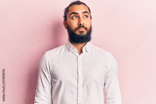 Young arab man wearing casual clothes smiling looking to the side and staring away thinking. © Krakenimages.com
