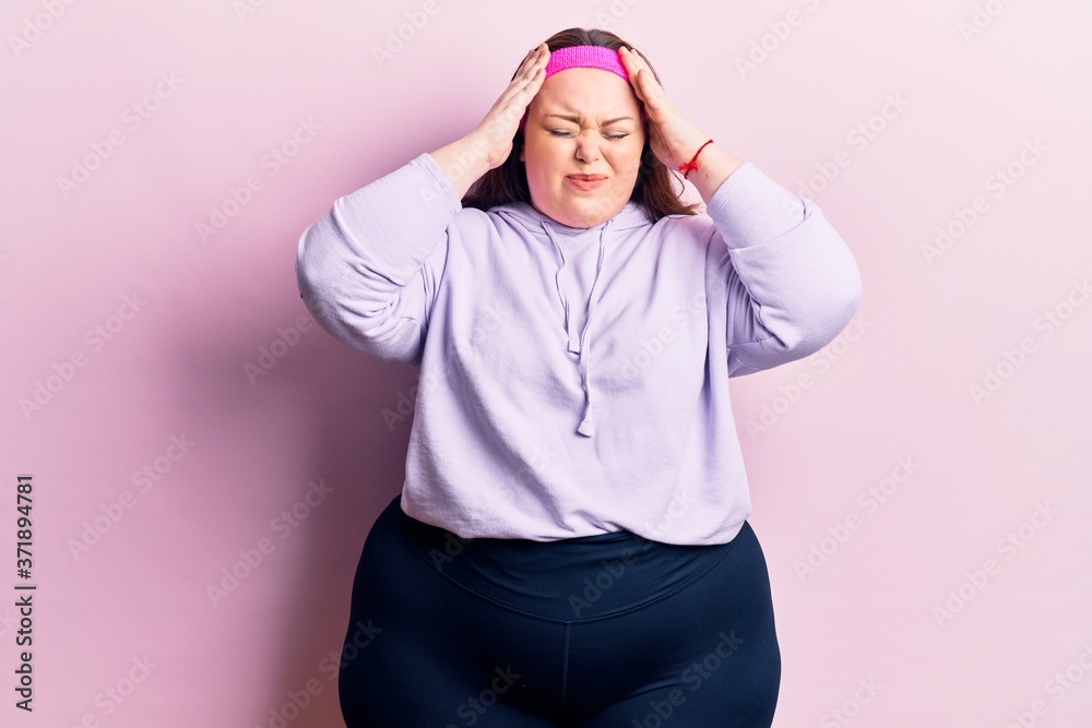 Young plus size woman wearing sportswear with hand on head, headache because stress. suffering migraine. Young plus size woman wearing sportswear with hand on head, headache because stress. suffering migraine.