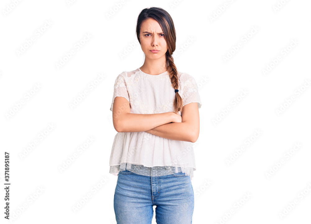 Young beautiful girl wearing casual t shirt skeptic and nervous, disapproving expression on face with crossed arms. negative person. Young beautiful girl wearing casual t shirt skeptic and nervous, disapproving expression on face with crossed arms. negative person.