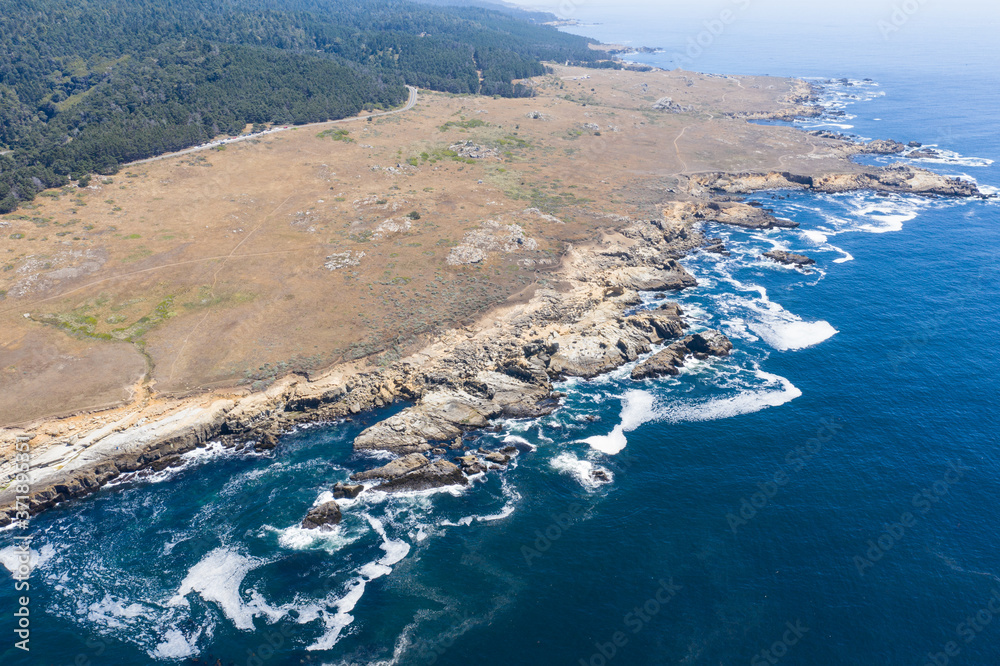 The Pacific Ocean washes along the rugged shoreline of Northern California on a calm day. This part of the west coast is one of the most beautiful areas in the United States.