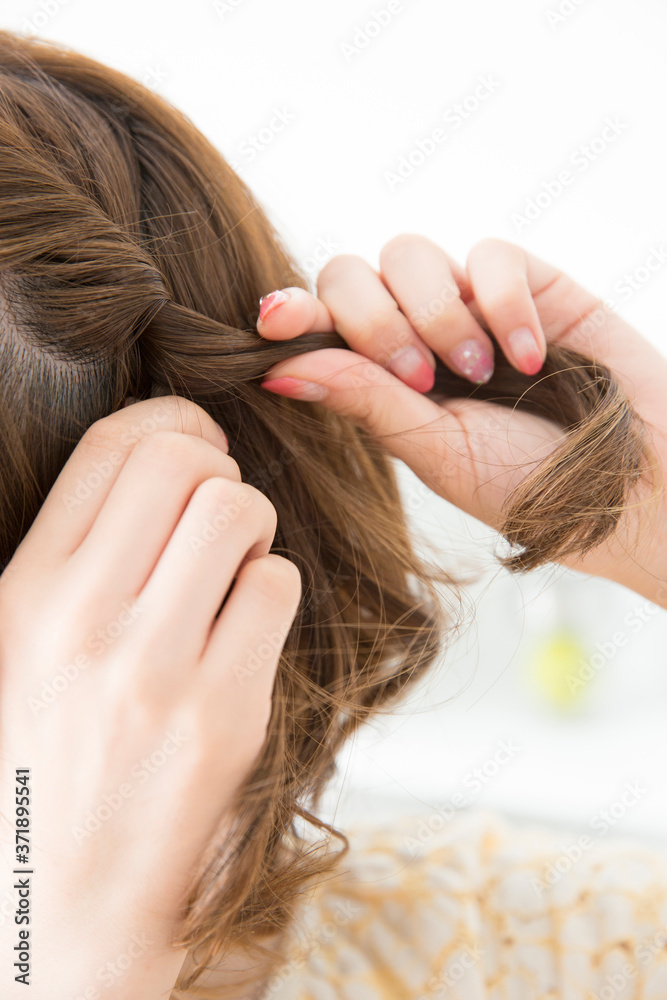 Obraz premium ヘアアレンジをする女性の手元