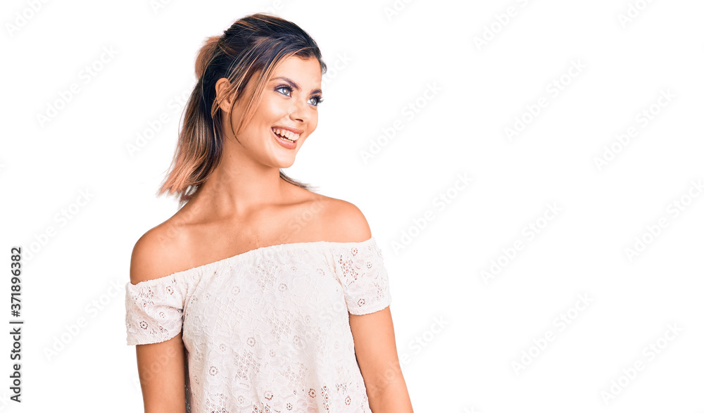 Young beautiful woman wearing casual clothes looking away to side with smile on face, natural expression. laughing confident. Young beautiful woman wearing casual clothes looking away to side with smile on face, natural expression. laughing confident.