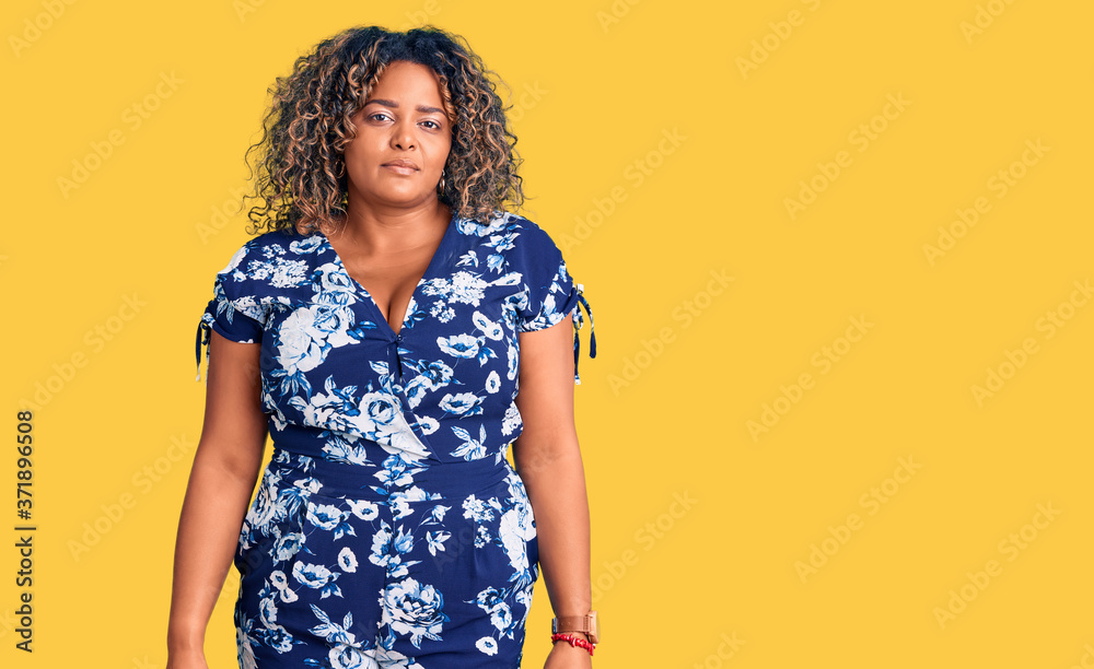 Young african american plus size woman wearing casual clothes relaxed with serious expression on face. simple and natural looking at the camera. Young african american plus size woman wearing casual clothes relaxed with serious expression on face. simple and natural looking at the camera.