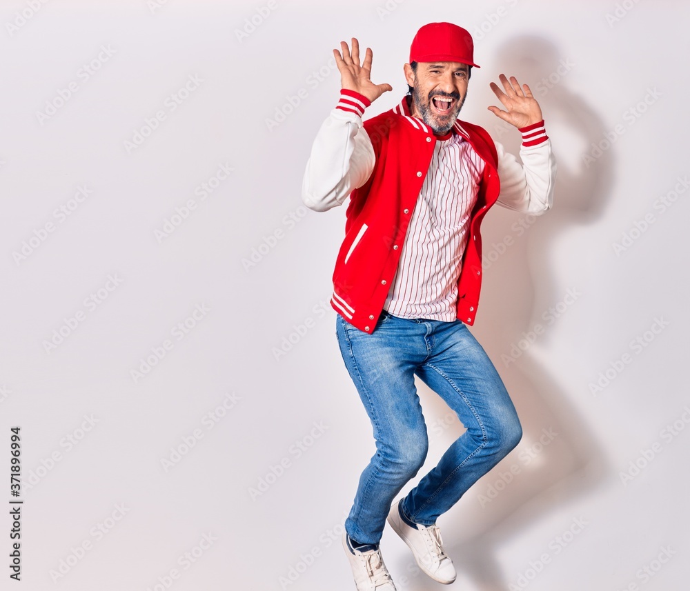 Middle age handsome man wearing baseball uniform smiling happy. Jumping with smile on face over isolated white background Middle age handsome man wearing baseball uniform smiling happy. Jumping with smile on face over isolated white background