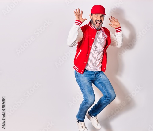 Middle age handsome man wearing baseball uniform smiling happy. Jumping with smile on face over isolated white background © Krakenimages.com