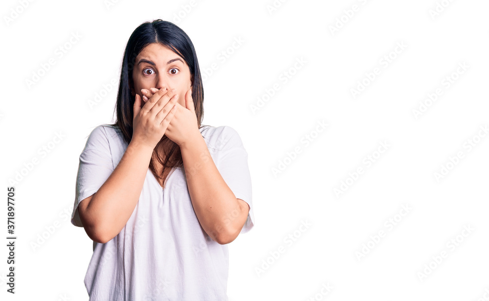Young beautiful brunette woman wearing casual t-shirt shocked covering mouth with hands for mistake. secret concept. Young beautiful brunette woman wearing casual t-shirt shocked covering mouth with hands for mistake. secret concept.