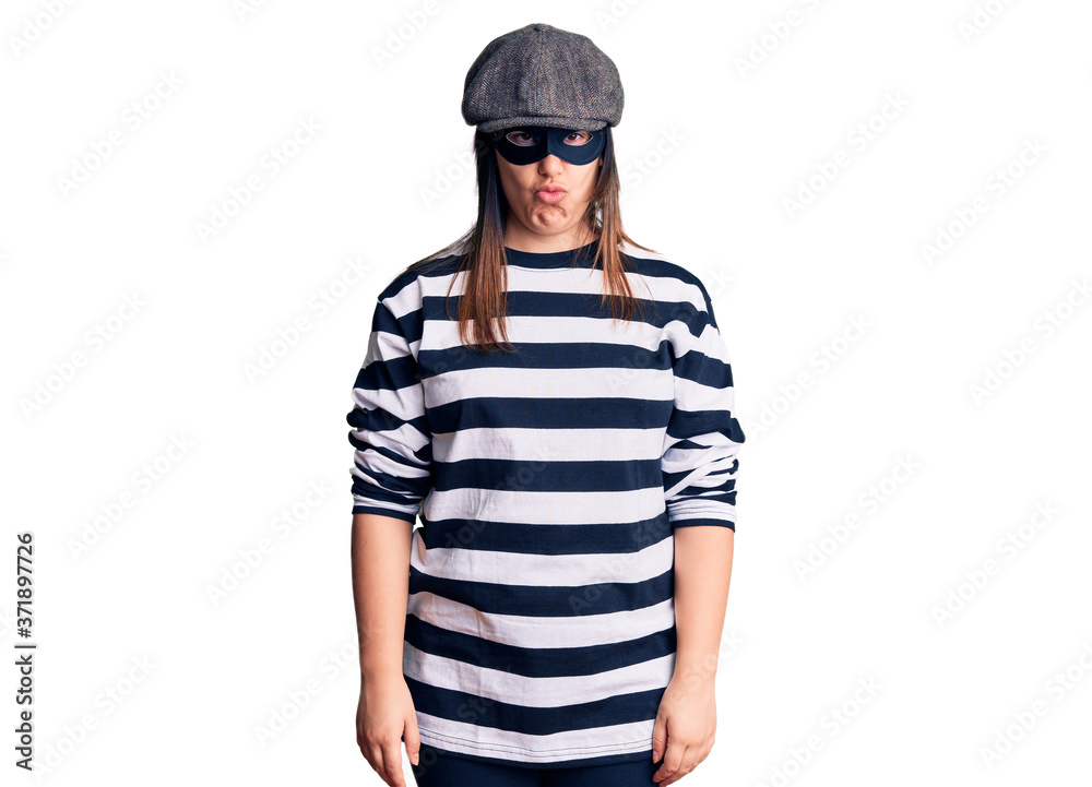 Fototapeta premium Young beautiful brunette woman wearing burglar mask skeptic and nervous, frowning upset because of problem. negative person.