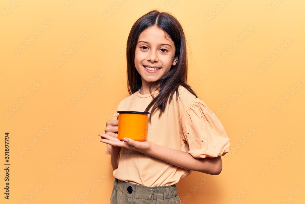 Beautiful child girl holding coffee looking positive and happy standing and smiling with a confident smile showing teeth Beautiful child girl holding coffee looking positive and happy standing and smiling with a confident smile showing teeth