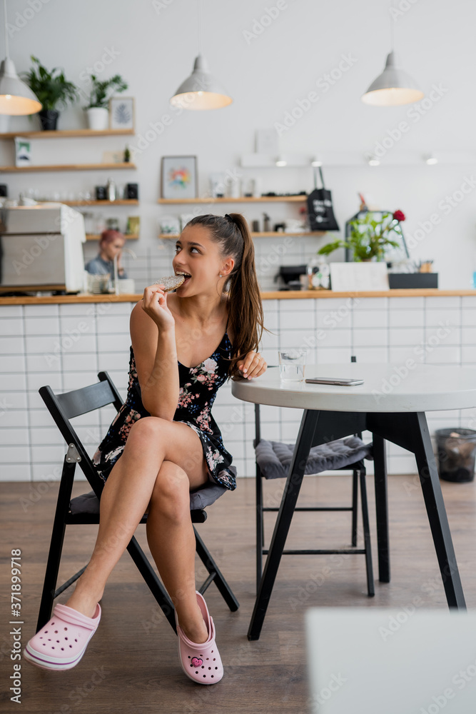 Happy smiling girl holds cookie in a cozy cafe. Happy smiling girl holds cookie in a cozy cafe.