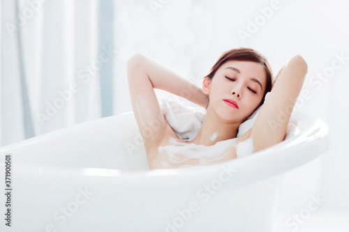 Beautiful young woman relaxing in bathtub