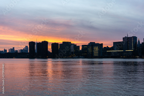Sunset of Manhattan Skyline in New York City. Silhouette of skyscrapers along East River © Renata