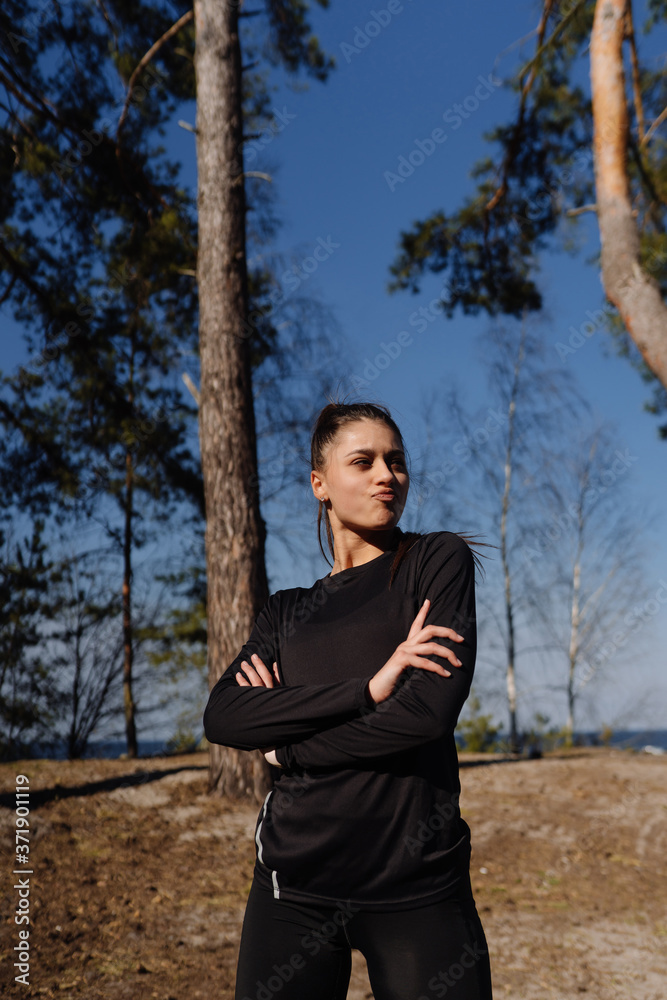 Fitness young woman walks in the park and posing for the camera