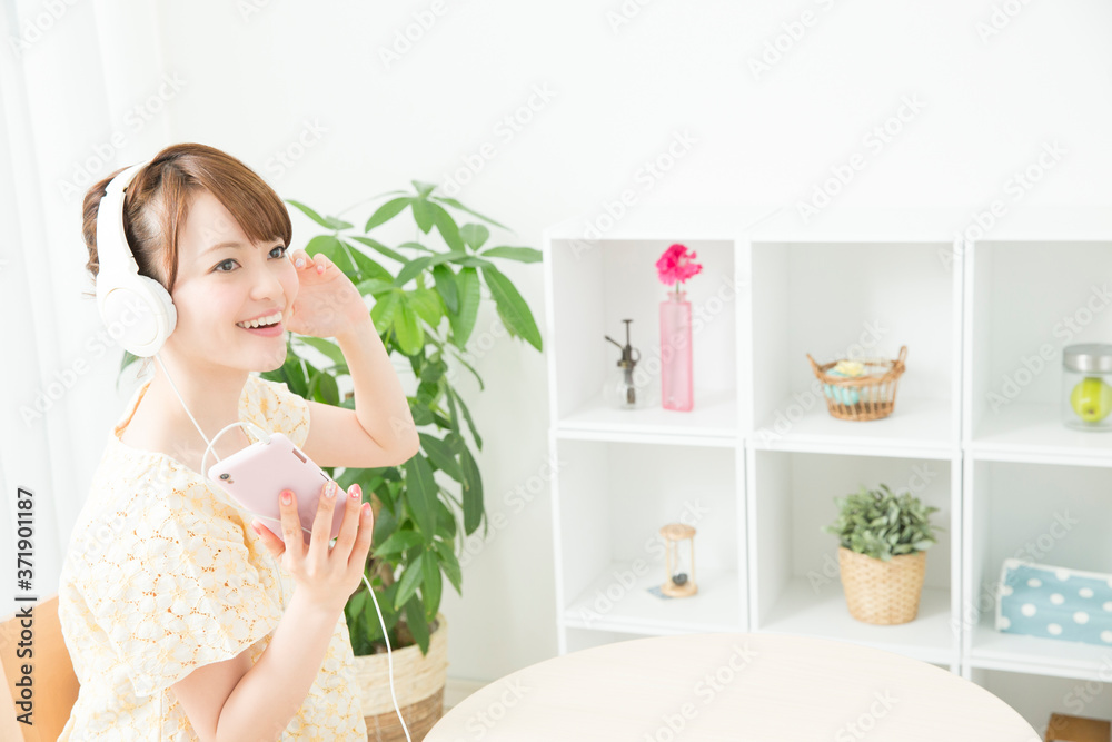 部屋で音楽を聴く女性 部屋で音楽を聴く女性