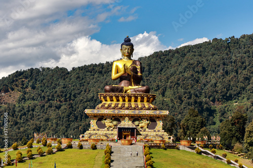A selective focus image of Buddha statue at Buddha park with snow clad himalayan mountain range in the background as seen from Rabongla in Sikkim India