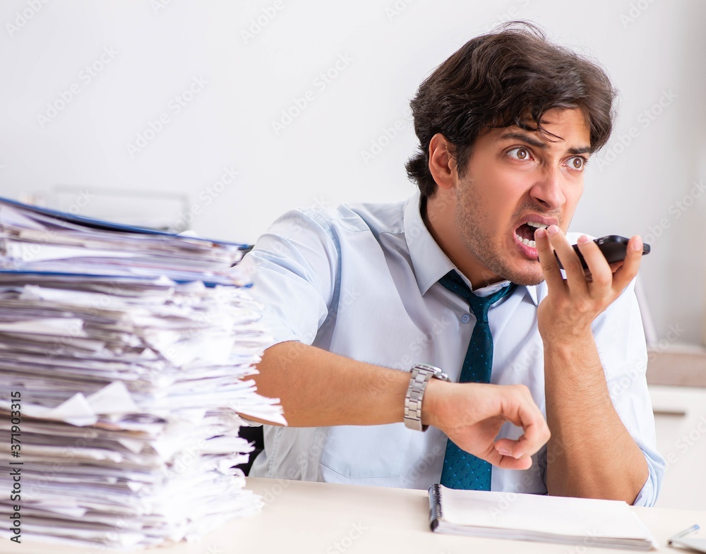 Overloaded busy employee with too much work and paperwork Overloaded busy employee with too much work and paperwork