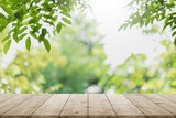 Empty wood table top and blurred green tree in the park garden background - can used for display or montage your products.