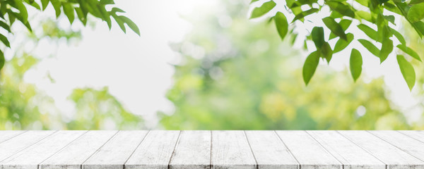 Empty wood table top and blurred green tree in the park garden background - can used for display or montage your products.