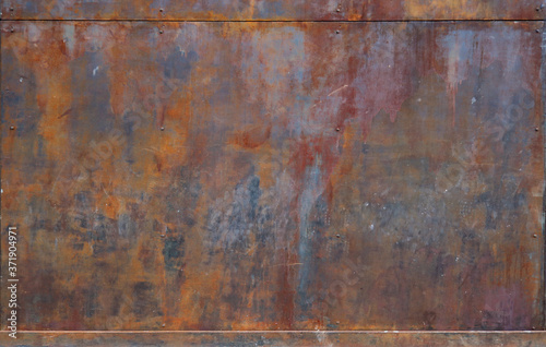 rusty metal surface with red, black and orange tones, framed up and down - worn irregular steampunk background with scratches 