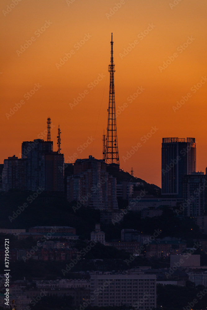 Dawn in Vladivostok. The TV tower stands on a hill against the backdrop of a bright dawn