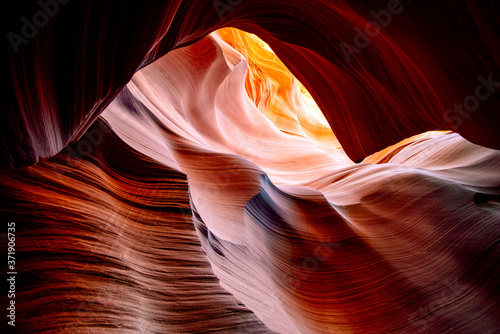 Light in Lower Antelope Canyon in Page Arizona with natural landscapes of bright sandstones stacked in flaky fire waves in a narrow sandy labyrinth with caves