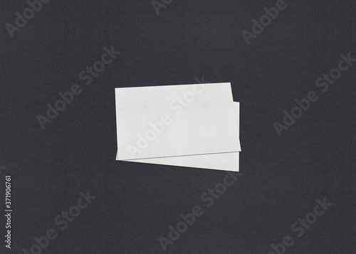 Blank white Business card mockup stacks on grey textured paper background.