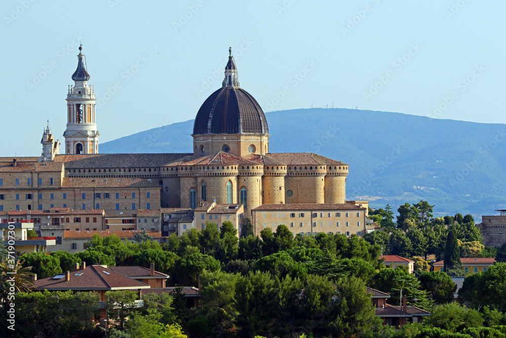The basilica of the holy house or santuario della santa casa in Loreto province of Ancona in Le Marche Italy with a field of yellow flowers a place of pilgrimage for Catholics and twinned with Lourdes