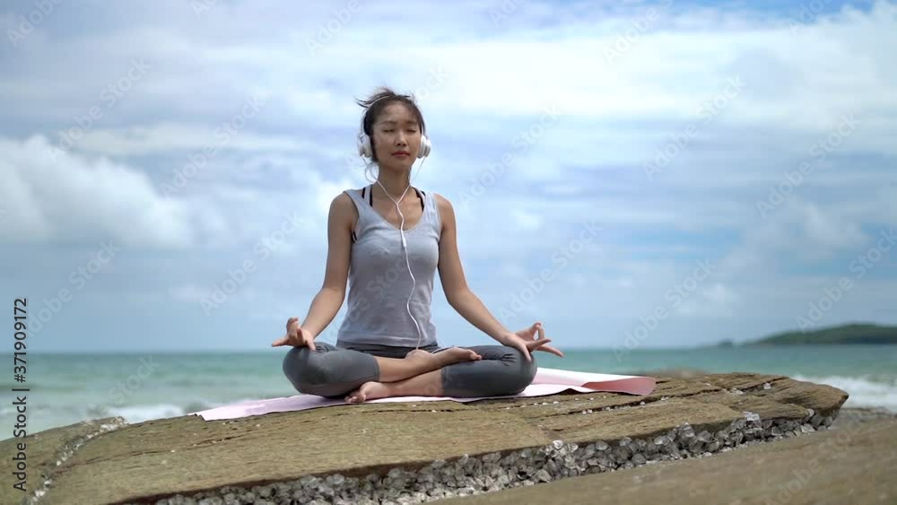 Slow motion clips,Beautiful woman practicing yoga on the rocks at the beach,Koh Samed Thailand. Slow motion clips,Beautiful woman practicing yoga on the rocks at the beach,Koh Samed Thailand.