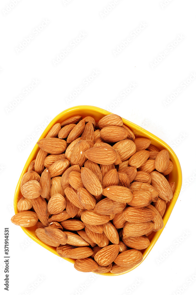 Group of almonds inside and outside bowl isolated on white. Group of almonds inside and outside bowl isolated on white.