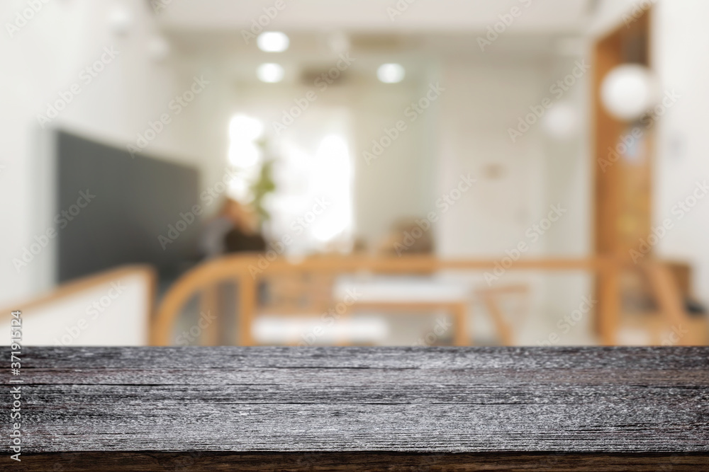 coffee shop blurred background with empty wooden desk montage. coffee shop blurred background with empty wooden desk montage.
