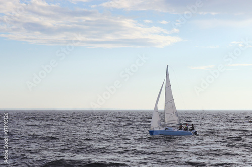 A sailing boat sails on the sea. Open sails. Active sport. Sailing on a yacht. © Valentina Shilkina