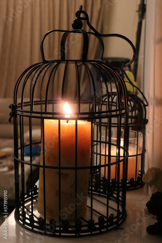 Lighted candle in a black cage