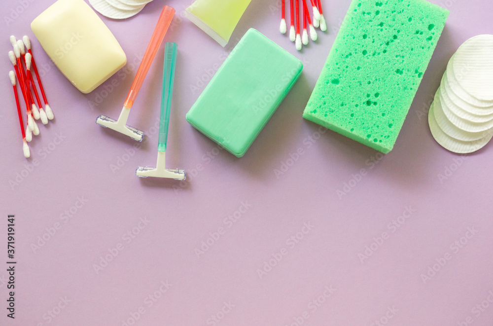 Flat lay of bath and hygiene products. Razors, soap bars and washcloth on a lilac background. Space for text Flat lay of bath and hygiene products. Razors, soap bars and washcloth on a lilac background. Space for text