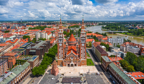 Szeged, Hungary - Aerial panoramic view of the Votive Church and Cathedral of Our Lady of Hungary (Szeged Dom) on a sunny summer day with Inner Town Bridge (Belvarosi hid) and blue sky and clouds