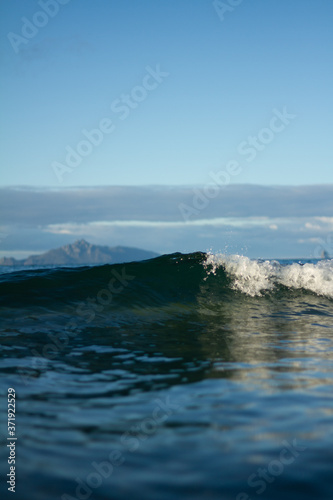 Small waves breaking on a surf beach, New Zealand. 