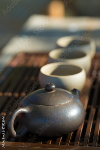 Chinese tea ceremony. Ceramic teapot made of clay and bowls on a wooden background.