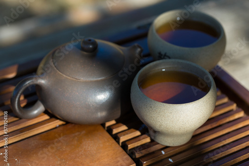 Chinese tea ceremony. Ceramic teapot made of clay and bowls on a wooden background.